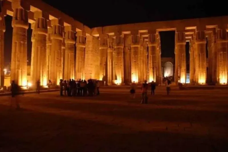 Philae Temple carved reliefs illuminated at night — Isis and Osiris myth depicted in stone
